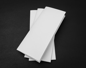 Trifold white template paper on black background .