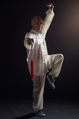 Senior man practicing Tai Chi with sword