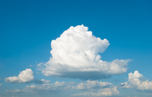 Huge White Cumulus Cloud Against The Blue Sky