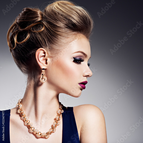 Naklejka na szybę Beautiful woman with style hairstyle and gold jewelry with brig