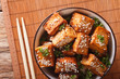 Stir fry tofu with sesame seeds and herbs close-up. horizontal top view