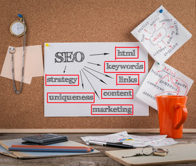 Canvas Print - SEO concept on cork board. Wooden office desk with a big mess