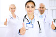 © rogerphoto - Happy doctor woman  with medical staff at the hospital. Thumbs up and Ok sign!