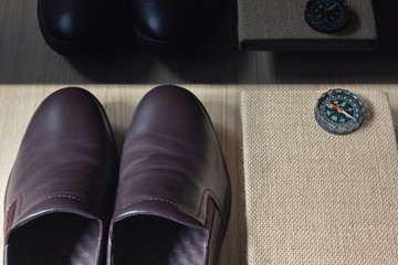 Man brown leather shoes with note book or diary with compass