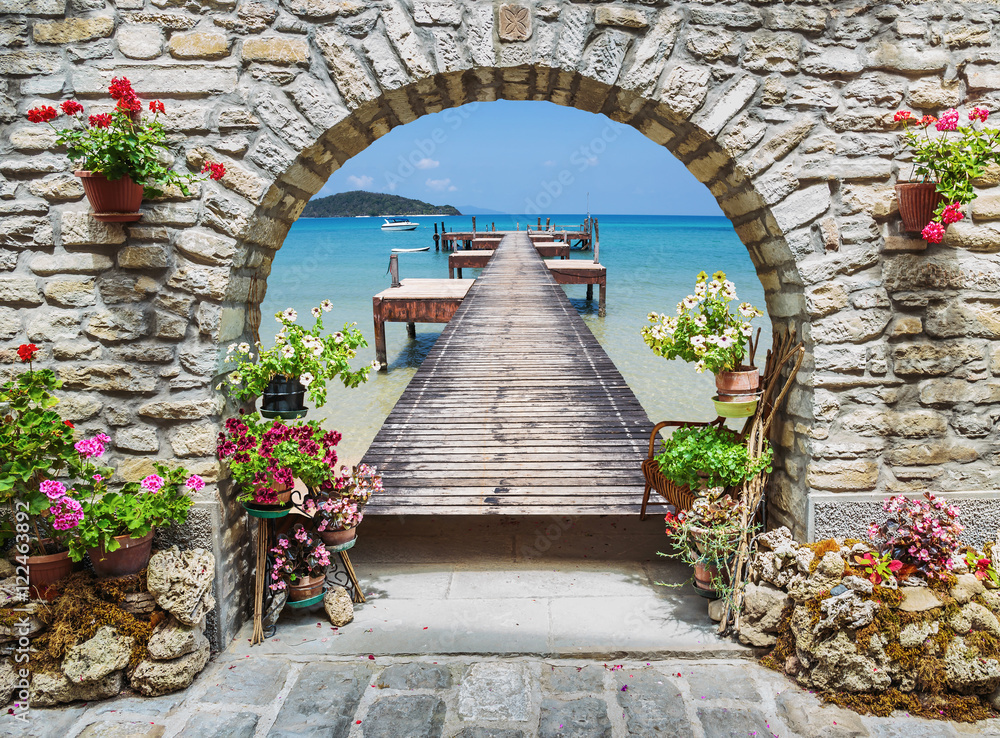 Seaview through the stone arch with flowers - obrazy, fototapety, plakaty 