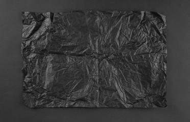 Sheet of black crumpled paper on black