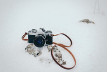 Vintage Film Camera On Rock In Snowy Landscape