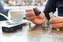 Man Filling An Electronic Cigarette Or Vaporizer With E-liquid