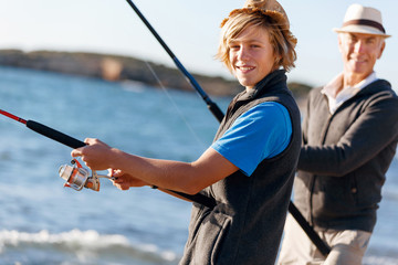 Wall Mural - Senior man fishing with his grandson