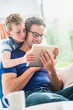 © jackfrog - At home, a father and his young son sharing a video on a tablet