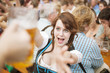 © tiagozr - Excited girl reaches for a mug of beer at Oktoberfest