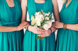 bridesmaids in green dresses with a white bridal bouquet