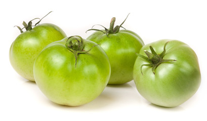 four green unripe tomato isolated on white background