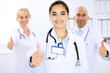 © rogerphoto - Happy doctor woman  with medical staff at the hospital. Thumbs up and Ok sign!
