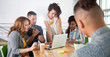 © AYAimages - Multi ethnic group of succesful creative business people using a laptop during candid meeting