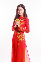 Beautiful Vietnamese woman with red ao dai holding lucky stack of gold for celebrate lunar new year on white background