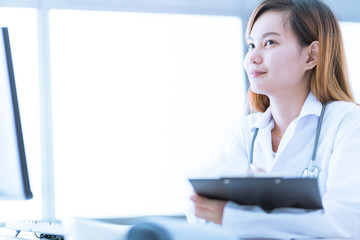 Portrait of a smiling physician working in her office. Asia