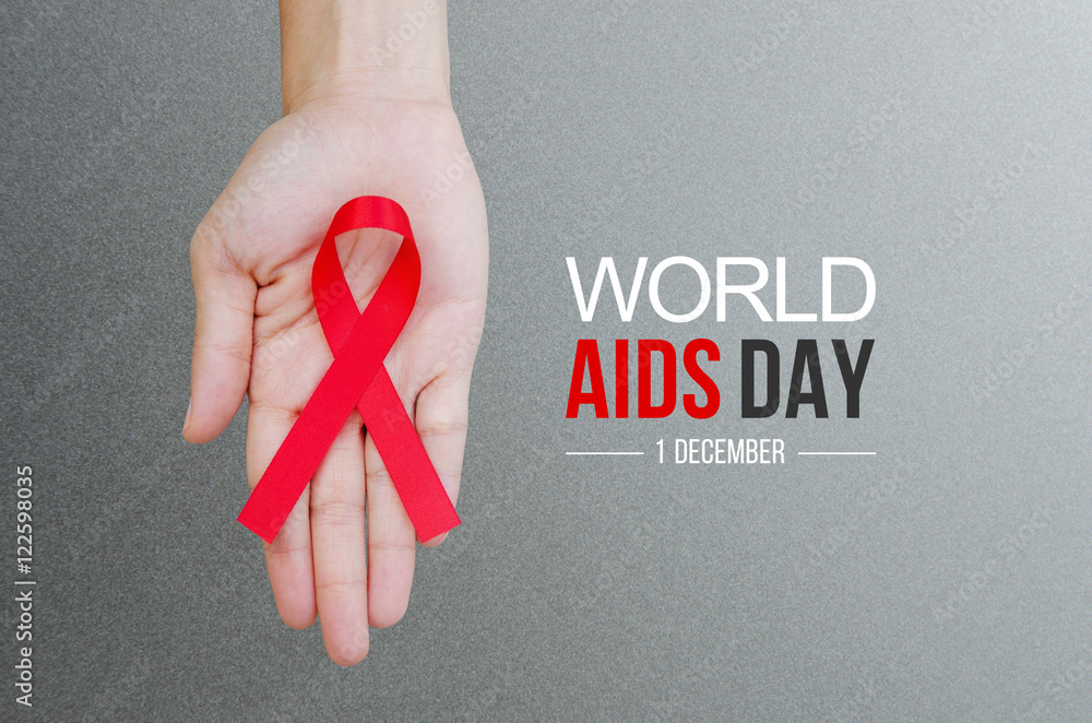 Female hands holding red ribbon HIV, AIDS awareness ribbon. World Aids Day concept. - obrazy, fototapety, plakaty 