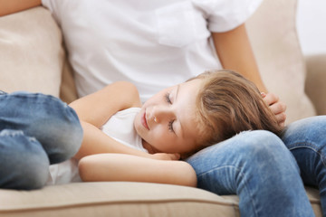 Sticker - Cute girl lying on mothers knees at home