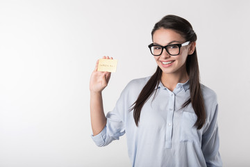 Delighted smiling woman holding gold card.