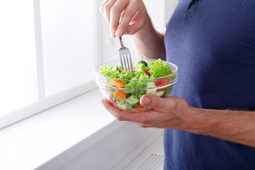 Wall Mural - Unrecognizable man has healthy lunch, eating diet vegetable sala