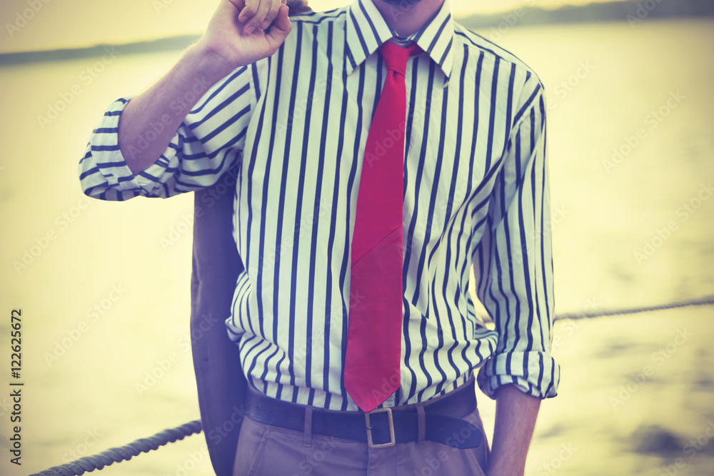 Man in striped shirt and red leather tie on a pier