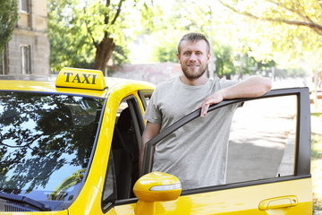 Wall Mural - Handsome taxi driver near car on station