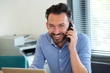 Wall Mural - Confident mature guy talking on mobile phone and smiling