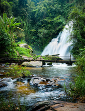 Tropical Rain Forest Landscape With Jungle Plants, Flowing Water Of Pha Dok Xu Waterfall And Bamboo Bridge. Mae Klang Luang Village, Doi Inthanon National Park, Chiang Mai Province, Thailand