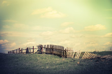 Sunny Day In Countryside. Summer Landscape With Old Broken Fence At Pasture  Under Blue Cloudy Sky. Nature Background In Vintage Style