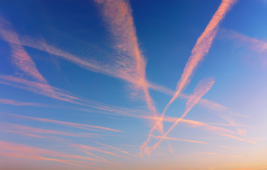 Wall Mural - cloudscape with airplane trails at sunset