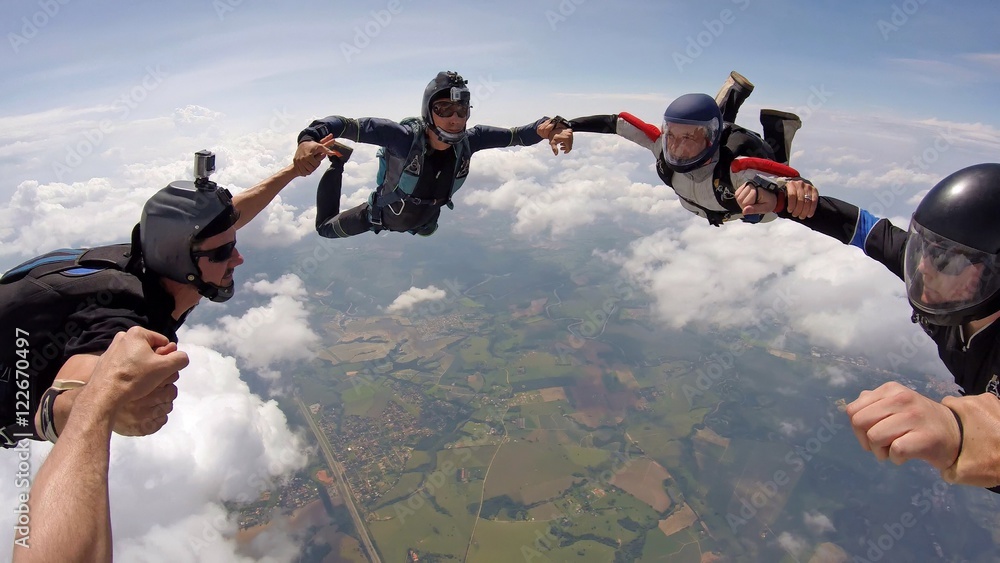 A group of friends holding hands teamwork skydiving - obrazy, fototapety, plakaty 