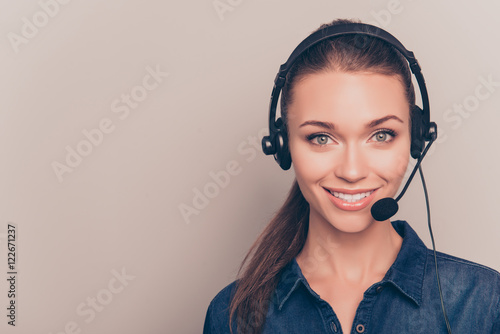 Fotografía Beautiful consultant of call center in headphones on gray backgr
