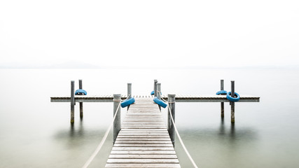 Wall Mural - Autumn. Wooden pier on the lake. Fog. Long exposure. 