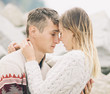 © stebliuk - Young attractive couple in knitted sweaters hugs each other with tenderness