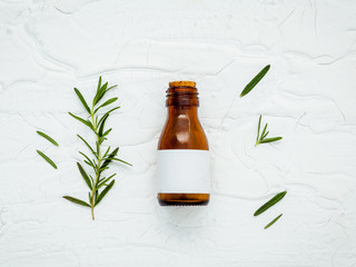 Wall Mural - Fresh branch of rosemary  with bottle essential oil setup on whi