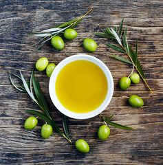 Wall Mural - Fresh green olives with leaves and olive oil on wooden backgroun