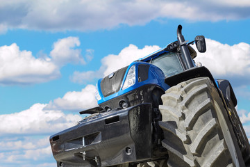 Fototapete - Tractor on a background cloudy sky