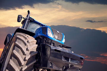 Poster - Tractor working on a sunset background