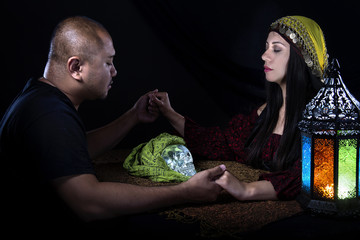 Psychic or fortune teller gypsy with a client doing a seance telepathic ritual