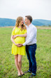 © demchyna - Happy pregnant couple looking at each other, holding belly and smiling. The idea for shooting outdoors pregnancy