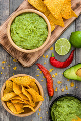 Wall Mural - Nachos, guacamole and ingredients on wooden table

