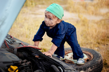 Little boy mechanic repairing the car