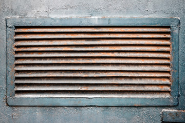 Rusty ventilation grille in metal wall