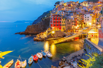 Wall Mural - Night aerial view of Riomaggiore fishing village, seascape in Five lands, Cinque Terre National Park, Liguria, Italy.