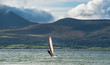 Wind surfing on the west coast of Ireland with wild rugged natural landscape in the background