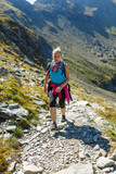 Fototapeta Las - Woman backpacker hiking on a trail