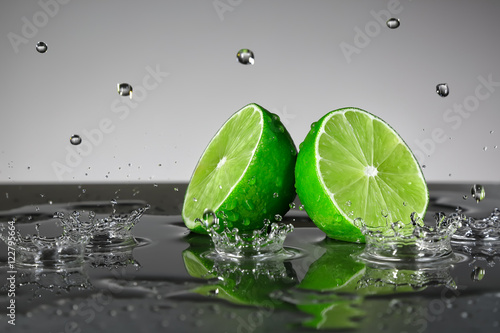 Fototapeta na wymiar Lime with water drops on grey background