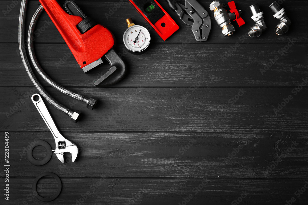 Plumber tools on a gray wooden background - obrazy, fototapety, plakaty 