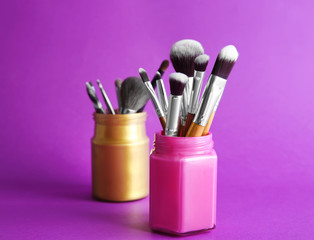 Wall Mural - Set of professional makeup brushes on color background, closeup